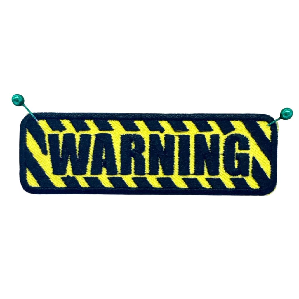 Warning kangasmerkki - Hoopee.fi